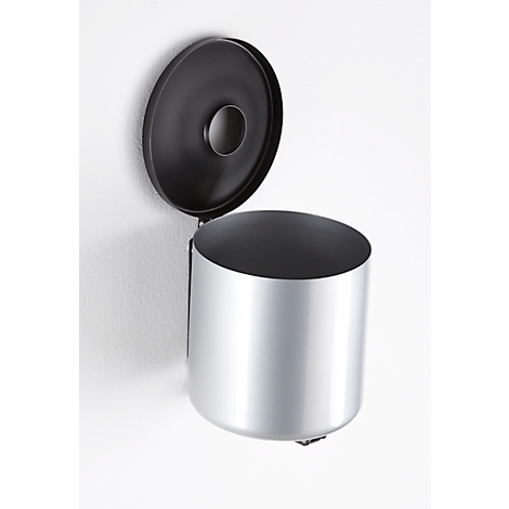Silver wall-mounted waste bin with open black lid on white wall. The hole in the lid is visible.