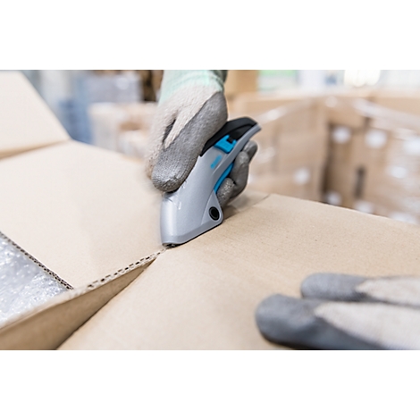 Person in gray gloves cutting open a cardboard box with a gray cutter.