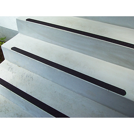 Concrete steps with black anti-slip strips. The angle of view is slightly from below.