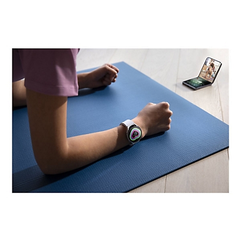 Person in Plank-Position auf blauer Matte mit Smartwatch und Handy, das Workout anzeigt.