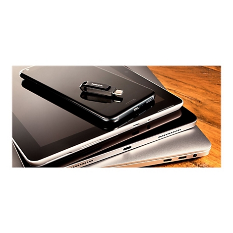Schwarzes Smartphone, Tablet und Laptop übereinander. Darauf ein USB-Stick mit SanDisk-Logo.