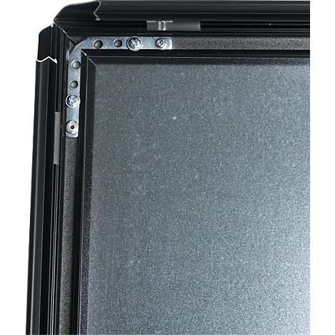 Close-up of a black frame construction with silver screws and gray surface.