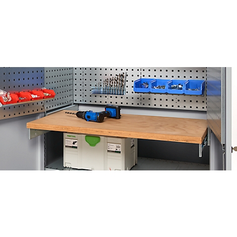 Établi avec plateau en bois, perceuse, mèches et outils bleus. Le mur du fond a des trous et des supports pour accessoires.