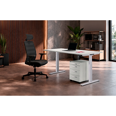 Espace de travail moderne avec un bureau blanc réglable en hauteur, une chaise de bureau noire et un caisson à tiroirs.