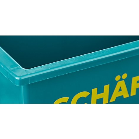 Gros plan d'une boîte turquoise avec l'inscription jaune 'SCHÄ'.