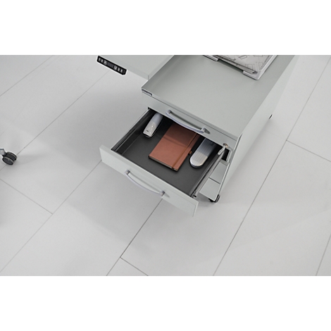 Bureau avec tiroir ouvert. Contenu : carnet, souris, stylos.