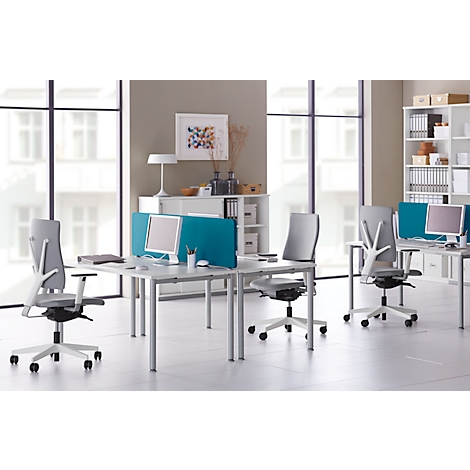 Espacio de oficina luminoso con escritorios, sillas de oficina y computadoras. Ventanas, estanterías con archivos y decoraciones.