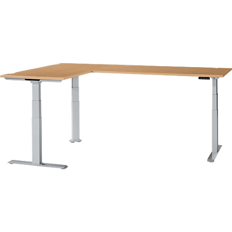 An L-shaped adjustable height desk. Light wood table top and light grey frame. Controls on the right side. White background.