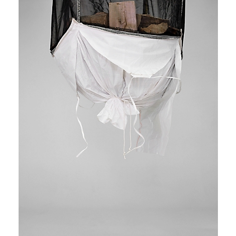 Vue d'en haut, une structure en filet noir soutenant un sac en tissu blanc contenant des morceaux de bois. Le sac est noué avec des ficelles.