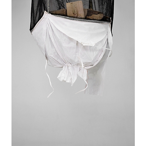 Objet composé de filet noir, sac blanc, bois et ficelle. Suspendu sur fond gris.