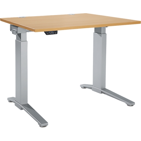 Bureau réglable en hauteur avec un plateau de table brun clair et des pieds argentés. Panneau de commande sous la table.