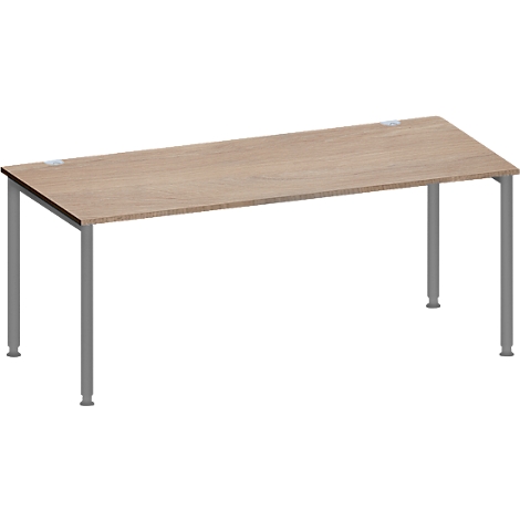 Een rechthoekige tafel met een lichtbruin tafelblad en zilveren poten. De poten zijn recht en op de hoeken van de tafel geplaatst.