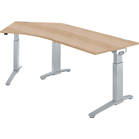 A height-adjustable desk with a light wood top and silver legs. The tabletop has a curved shape.