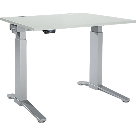 A height-adjustable desk, light grey tabletop, grey legs.