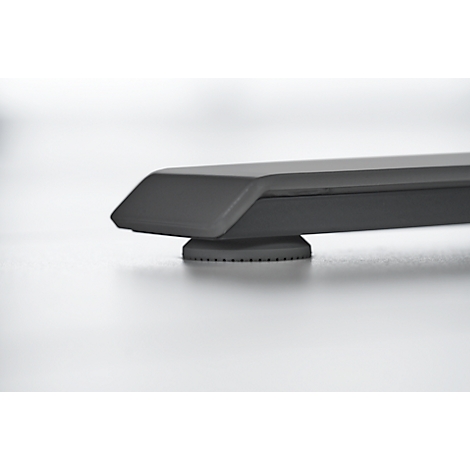 Close-up of a black furniture foot. The foot has a rectangular shape, with rounded edges and a textured underside.