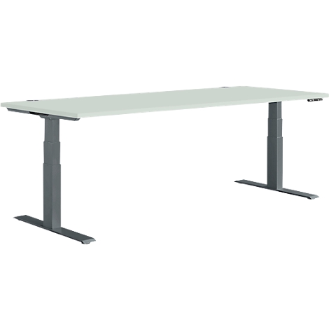 A height-adjustable desk with gray legs and a light-colored tabletop. The controls are on the right side.