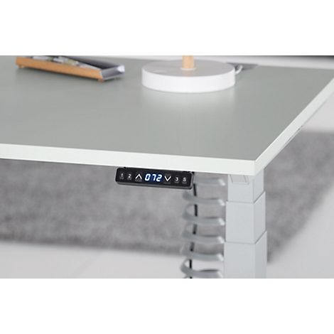 Close-up of a height-adjustable desk. A digital display shows the height.