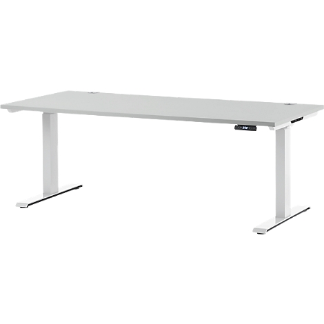 A white height-adjustable desk with a light tabletop design. A control for height adjustment is attached to the desk leg.
