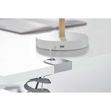 Close-up of a white desk clamp with a gray lamp attached. The base of the lamp with a USB port is visible in the background.