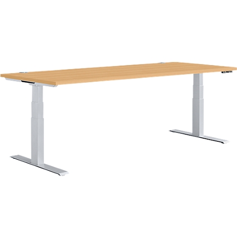 A height-adjustable desk with a light brown tabletop and gray legs, set against a white background.