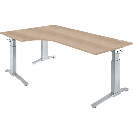 Corner desk with light brown tabletop and silver, height-adjustable legs, against a white background.