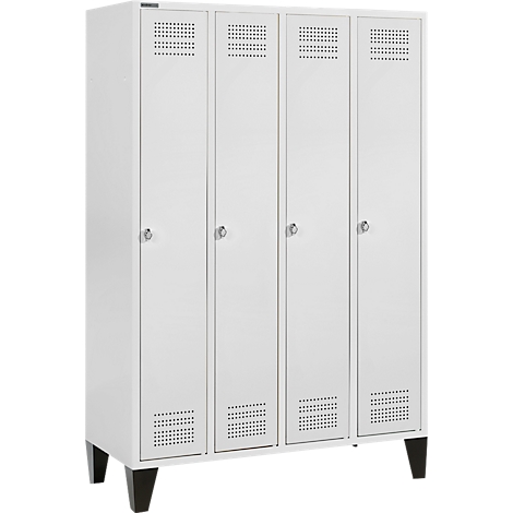 White locker with four doors, handles and ventilation holes. The locker stands on four black feet.