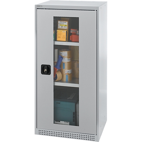 Gray steel cabinet with glass front. Inside, rolls of paper, tools, and boxes. Black door handle and ventilation slots.