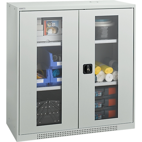 Gray cabinet with glass panes. Inside, shelves with office supplies, paper rolls and boxes.