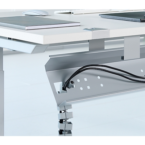 Detailansicht eines Schreibtisches mit Kabelmanagement. Schwarze Kabel verlaufen durch eine metallische Kabelrinne.