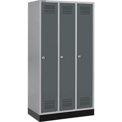 Grijze kast met drie deuren, kleine handvatten en ventilatiegaten, tegen een witte achtergrond.