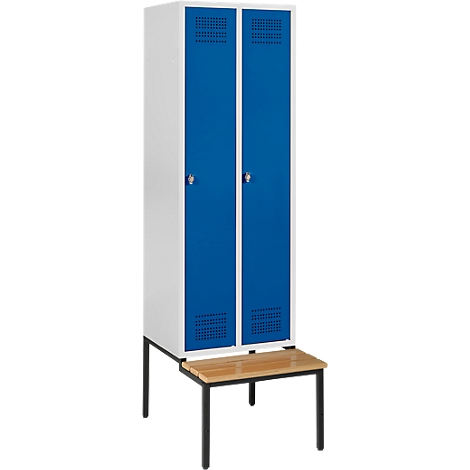 A white locker with two blue doors and a wooden bench.