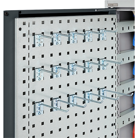 Metallhaken in Lochplatte. Mehrere Haken an einer perforierten Wand, angebracht.