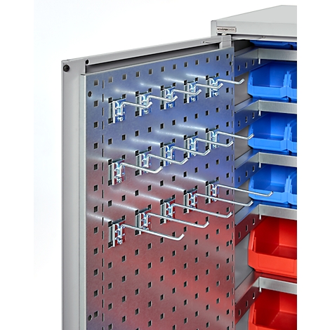 Schrank mit Lochwand und Haken. Blaue und rote Aufbewahrungsboxen sind zu sehen.