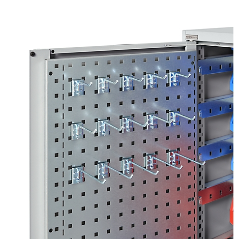 Metallschrank-Detailansicht: Lochblech mit Haken für Werkzeug und farbigen Leisten.
