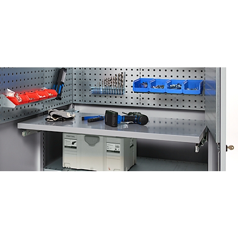 Tool cabinet with tools. Tools lie on a work surface. Drills, drawers and other accessories are on the back wall.