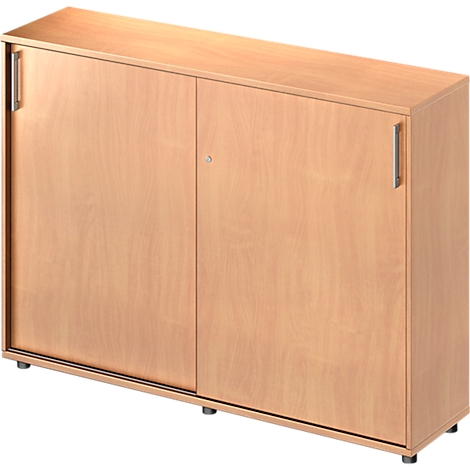 A light brown wooden cabinet with two doors. The doors have metal handles and a keyhole. The cabinet stands on small feet.