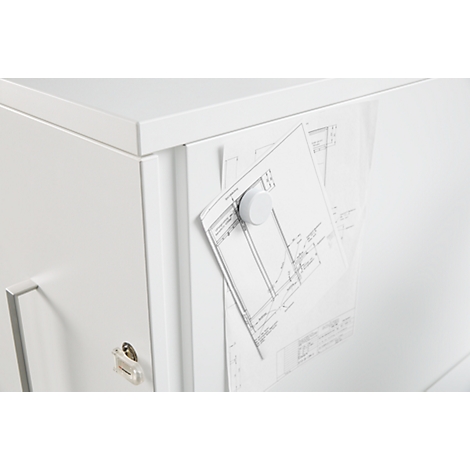 White magnet holding a drawing on a white drawer.