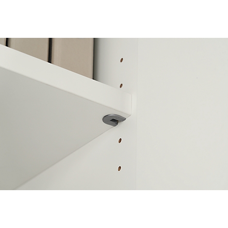 Close-up of a white shelf board with grey bracket. Below a white wall with pre-drilled holes.