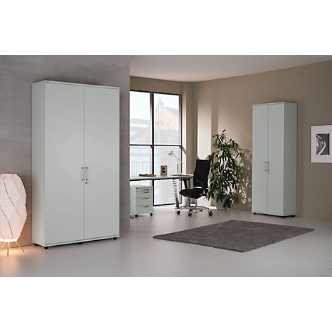 Office space featuring white cabinets, a desk, office chair, and plants. A rug is on the floor.