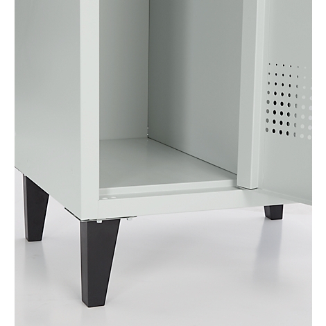 Gros plan sur une armoire gris clair avec la porte ouverte. Des pieds noirs soutiennent l'armoire.