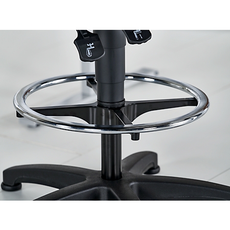 Detailaufnahme eines schwarzen Bürostuhls mit Fußstütze. Verchromte Fußstütze und schwarzes Gestell. Hebel und Beschriftungen.