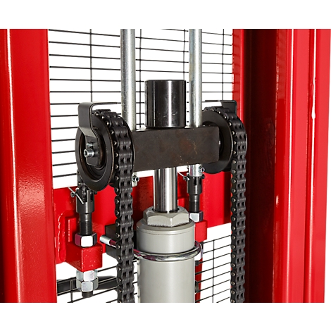 Close-up of a red lifting device featuring a sprocket and chain for lifting work.