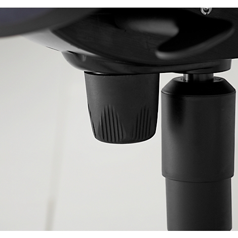 Close-up of a black object with a grooved surface. The background is white.