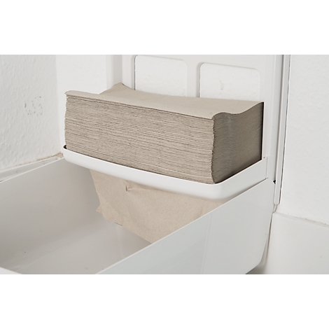 A white paper towel dispenser with folded paper towels in a neutral color.