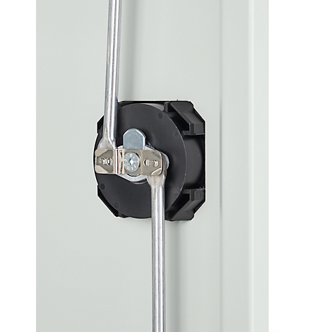 Close-up van een zwart kunststof apparaat met twee metalen staven en bevestigingsmiddelen tegen een lichtgrijze achtergrond.