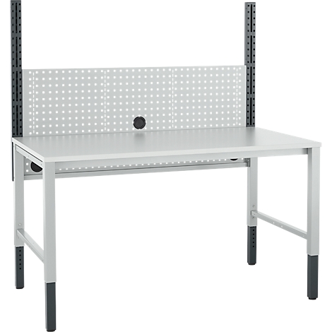 Grijze werkbanktafel tegen witte achtergrond. Geperforeerd plaatmetaal met structuren erboven.