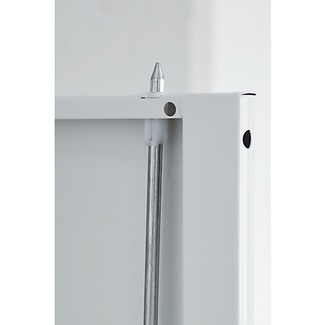 Close-up of a white frame with silver pin and pole. A hole and the tip are visible.