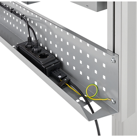 Close-up van een stekkerdoos in een kabelgoot. Zwarte stopcontacten, kabels, grijze metalen structuur met een gatenpatroon.