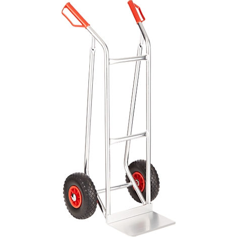 Transportkarre aus Metall, mit zwei Rädern und roten Griffen. Auf der Ladefläche ist die Karre abgeflacht.