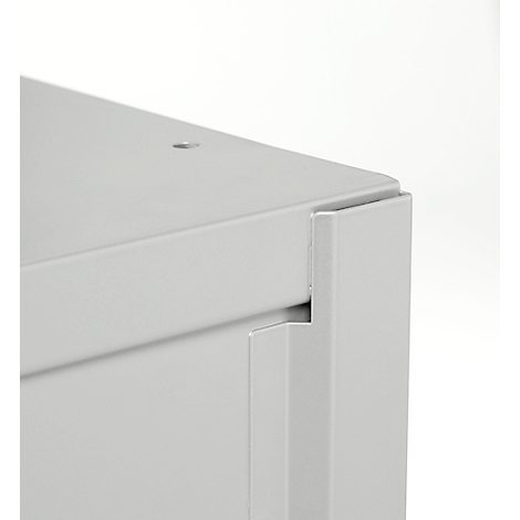 Gros plan sur le coin d'un objet gris rectangulaire. Les bords sont clairement définis et ont une surface lisse.
